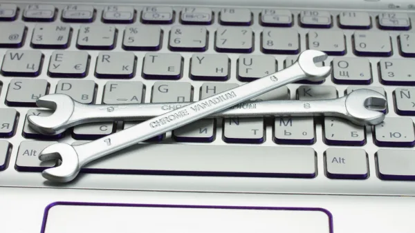 Two wrenches crossed on a computer keyboard