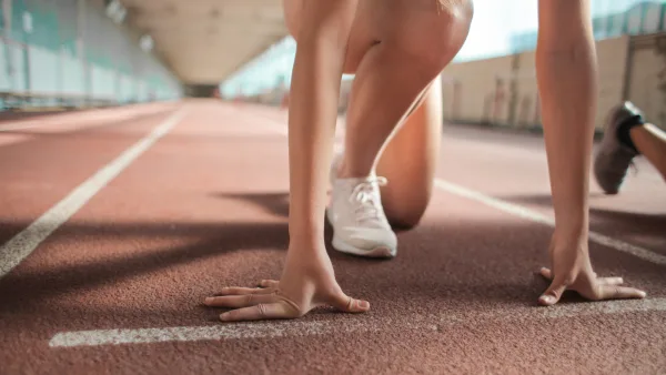 Hands and feet on the start line of a running track