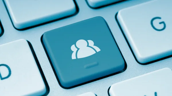 A keyboard button with the silhouette of three people